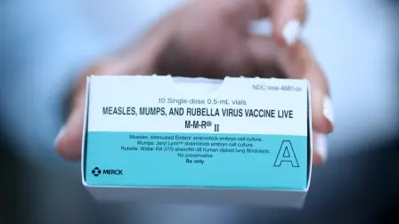 CORAL GABLES, FLORIDA - AUGUST 13: A Medical Assistant holds a box of measles, mumps and rubella, vaccine doses at the pediatric office of Dr. Gary M. Kramer on August 13, 2026, in Coral Gables, Florida. President Donald Trump signed an executive order on Monday to overhaul childhood vaccination policy.   Joe Raedle/Getty Images/AFP (Photo by JOE RAEDLE / GETTY IMAGES NORTH AMERICA / Getty Images via AFP)