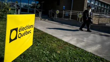 A person walks next to an election Quebec sign after casting their ballot during Quebecs provincial general election in Montreal, Quebec, Canada, on October 5, 2026. (Photo by ANDREJ IVANOV / AFP)