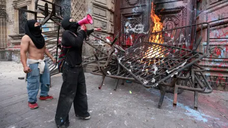 Encapuchados incendian una barricada en una de las puertas del Palacio de Gobierno de Jalisco durante una protesta por la crisis del agua en Guadalajara.