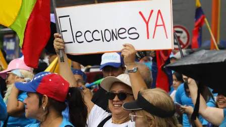 A supporter of Venezuela's opposition holds a sign reading "Elections now" during a demonstration to demand elections in 2027, in Valencia, Venezuela, October 22, 2026. REUTERS/Juan Carlos Hernandez
