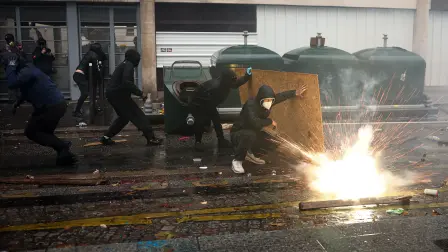 Manifestantes se refugian de los gases lacrimógenos durante una protesta en París, Francia, contra el alto costo de vida y en defensa de los servicios públicos. Foto: AFP.
