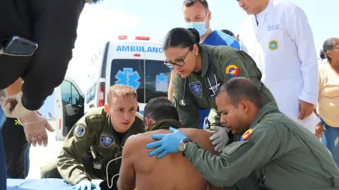 Miembros de la fuerza trasladando a un policía herido tras un ataque guerrillero.