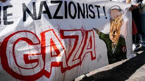 Manifestantes sostienen una pancarta con la imagen del primer ministro israelí, Benjamin Netanyahu.