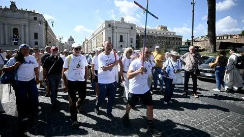 Peregrinos marchan ante la Puerta Santa de la Basílica de San Pedro durante el Jubileo LGTB en el Vaticano.