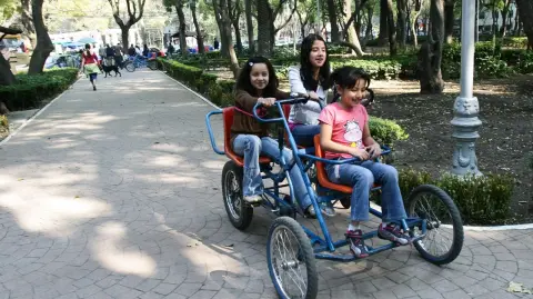 Un grupo de niñas se divierten en triciclos que rentan en el Parque México de esta ciudad.