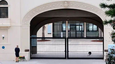 Un hombre presenta sus respetos después de depositar flores en la entrada del Bondi Pavilion en Sydney, un día después de un tiroteo.
