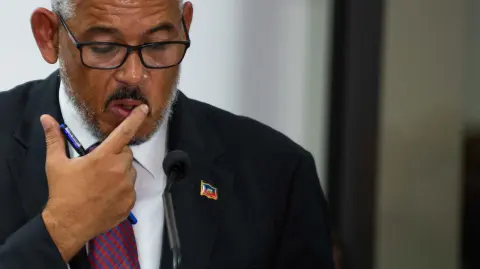 Newly sworn-in Haitian Prime Minister Alix Didier Fils-Aime speaks during the installation ceremony in Port-au-Prince, Haiti, on November 11, 2024. Fils-Aime was sworn in as Haitis new prime minister, promising to restore security and tackle gang violence in the crisis-wracked country. Fils-Aime replaced Garry Conille, who was appointed in May, as a gun attack on a low-cost American airliner coming in to land in the capital illustrated the enormity of his challenge. (Photo by Clarens SIFFROY / AFP)