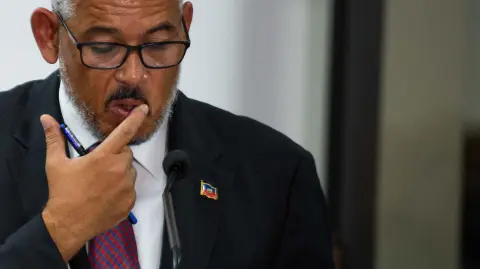 Newly sworn-in Haitian Prime Minister Alix Didier Fils-Aime speaks during the installation ceremony in Port-au-Prince, Haiti, on November 11, 2024. Fils-Aime was sworn in as Haitis new prime minister, promising to restore security and tackle gang violence in the crisis-wracked country. Fils-Aime replaced Garry Conille, who was appointed in May, as a gun attack on a low-cost American airliner coming in to land in the capital illustrated the enormity of his challenge. (Photo by Clarens SIFFROY / AFP)