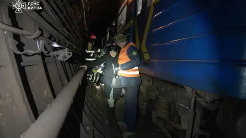 Rescatistas y trabajadores del metro ayudando a personas a salir del metro a través de túneles.