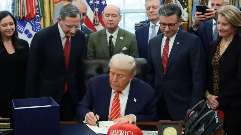 U.S. President Donald Trump signs a bill to end the partial government shutdown, while U.S. House Speaker Mike Johnson (R-LA), Senator Shelley Moore Capito (R-WV) and Senator John Barrasso (R-WY) stand by his side, at the White House in Washington, D.C., U.S., February 3, 2026. REUTERS/Evelyn Hockstein