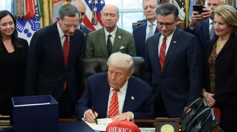 U.S. President Donald Trump signs a bill to end the partial government shutdown, while U.S. House Speaker Mike Johnson (R-LA), Senator Shelley Moore Capito (R-WV) and Senator John Barrasso (R-WY) stand by his side, at the White House in Washington, D.C., U.S., February 3, 2026. REUTERS/Evelyn Hockstein