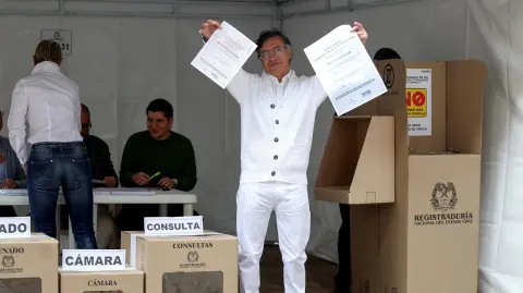 El presidente colombiano Gustavo Petro muestra las papeletas de votación antes de emitir su voto.