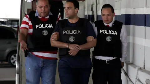 Former governor of Mexico's Quintana Roo state Roberto Borge is escorted by policemen at the facilities of the Investigation Police in Panama City