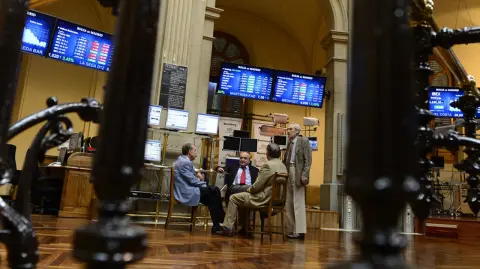 Traders sit next to the IBEX-35 index billboard on June 18, 2012 at Madrid