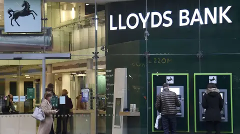 Customers use ATMs at a branch of Lloyds Bank in London - Customers use ATMs at a branch of Lloyds Bank in London, Britain, February 21, 2017. Picture taken February 21, 2017. REUTERS/Toby Melville
