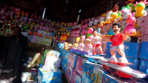 A seller waits for the customers near the toys depicting Liverpool