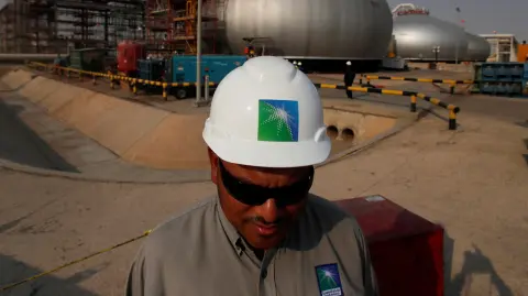 FILE PHOTO: An employee in a branded helmet is pictured at Saudi Aramco oil facility in Abqaiq, Saudi Arabia October 12, 2019. REUTERS/Maxim Shemetov/File Photo-NARCH/NARCH30