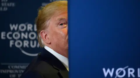 US President Donald Trump looks back as a question from the press is shouted after a press conference at the World Economic Forum in Davos, Switzerland, on January 22, 2020. (Photo by JIM WATSON / AFP)
