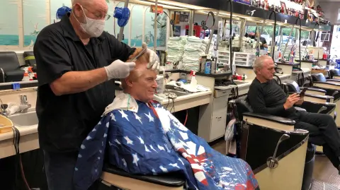 Barber Tommy Thomas gives his long-time customer Fred Bentley a haircut in Atlanta