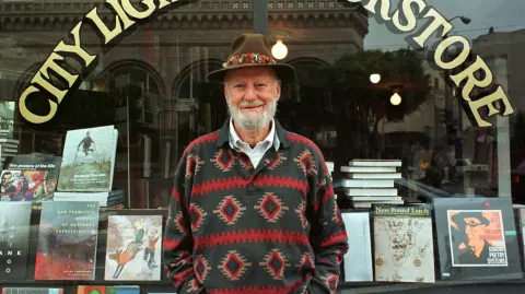 FILE PHOTO: Lawrence Ferlinghetti stands outside his bookstore in San Francisco