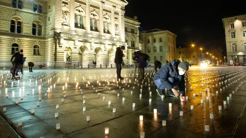 Los voluntarios encienden algunas de las más de 11.000 velas, una por cada víctima de la pandemia de la enfermedad del coronavirus (COVID-19) en Suiza, durante una vigilia con velas frente a la sede del parlamento federal suizo Bundeshaus en Berna, Suiza. Foto: Reuters.