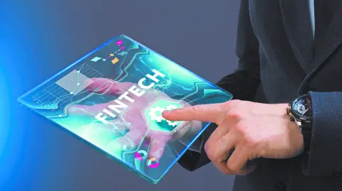 Business, Technology, Internet and network concept. Young businessman working on a virtual screen of the future and sees the inscription: Fintech