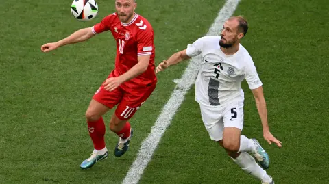 El centrocampista danés #10 Christian Eriksen y el defensor esloveno #05 Jon Gorenc Stankovic compiten por el balón. Foto: AFP