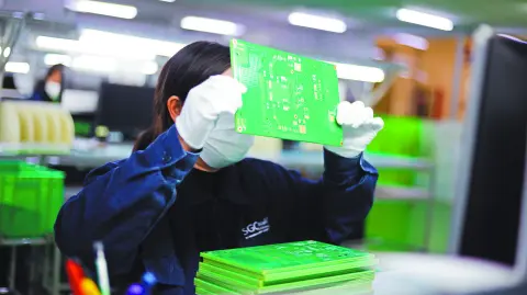 Jiujiang, China - May 26, 2021: Workers produce electronic equipment accessories such as circuit boards in a workshop of a high-tech enterprise in the economic and technological development zone.