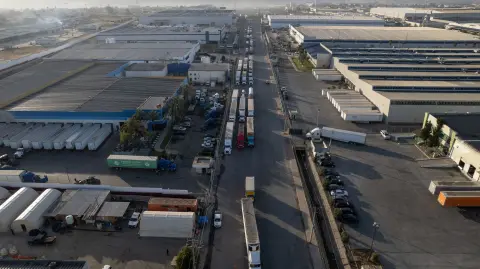 Vista aérea de camiones en cola esperando cruzar a los Estados Unidos junto al muro fronterizo en el puerto comercial de Otay en Tijuana, estado de Baja California, México.