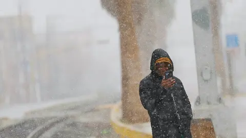 Migrante venezolano observa la nevada en Ciudad Juárez.