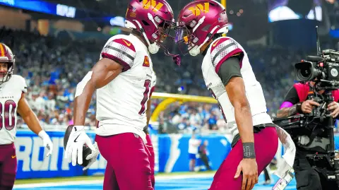 DETROIT, MICHIGAN - JANUARY 18: Terry McLaurin #17 of the Washington Commanders celebrates with Jayden Daniels #5 after catching a pass for a touchdown during the second quarter against the Detroit Lions in the NFC Divisional Playoff at Ford Field on January 18, 2025 in Detroit, Michigan.   Nic Antaya/Getty Images/AFP (Photo by Nic Antaya / GETTY IMAGES NORTH AMERICA / Getty Images via AFP)