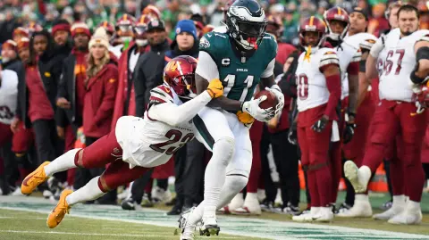 El receptor abierto de los Philadelphia Eagles, AJ Brown (11), corre con el balón contra el esquinero de los Washington Commanders, Marshon Lattimore (23)