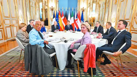 Al fondo, el anfitrión, el presidente francés Emmanuel Macron, junto a él, el canciller alemán Olaf Scholz.