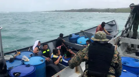 Esta fotografía publicada por el Senafront (Servicio Nacional de Fronteras) muestra a agentes de policía rescatando a migrantes que naufragaron cerca de Mansukum, territorio Guna Yala, Panamá.