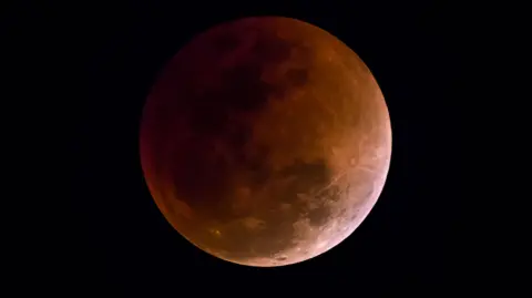 La Luna comenzó a teñirse de rojo este viernes debido a un eclipse total, un espectáculo poco frecuente que será seguido en dos semanas de un eclipse parcial del Sol.