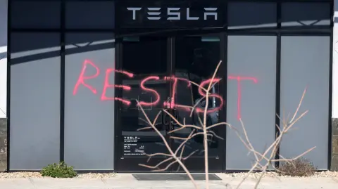 La palabra "RESIST" está pintada con aerosol en la entrada de un Centro de Colisiones de Tesla, como parte de lo que se calificó como "una ola de terrorismo interno contra Tesla".