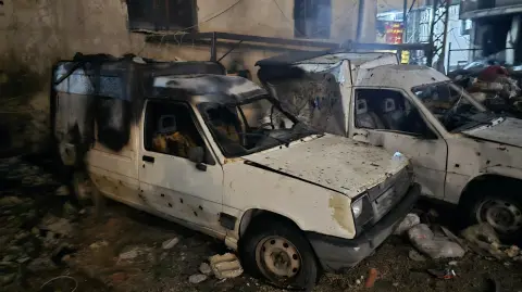 Autos dañados yacen en una calle después de un ataque israelí que tuvo como objetivo un barrio en la ciudad de Tiro.