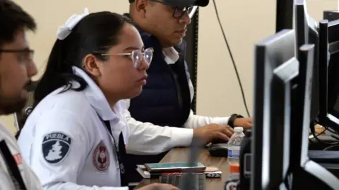 Agentes de la policía de Puebla monitorean denuncias ciudadanas.