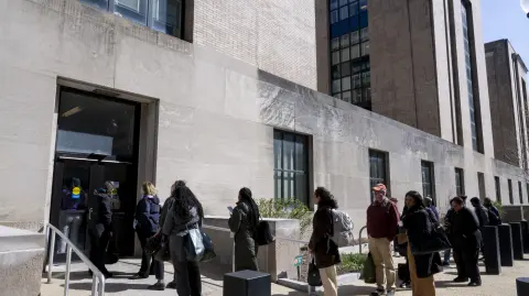 Trabajadores federales hacen fila para acceder al Edificio Conmemorativo Mary E. Switzer, sede del Departamento de Salud y Servicios Humanos de EU.