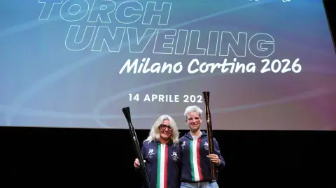 Las atletas Stefania Belmondo y Beatrice Vio sostienen las antorchas para los Juegos de Milán 2026.
