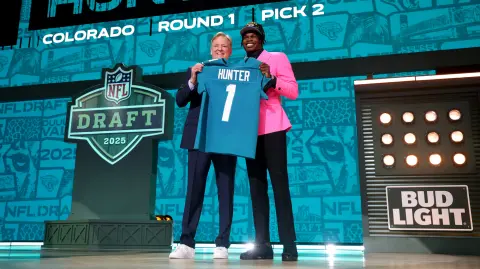 El receptor abierto/cornerback Travis Hunter, de Colorado, posa con el comisionado de la NFL, Roger Goodell.