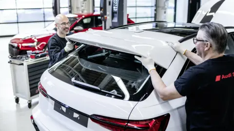 Two of the five employees who complete the assembly of the new Audi RS 6 Avant GT by hand at Böllinger Höfe. Numerous exterior parts, including the newly designed rear bumper, are made of carbon fiber.