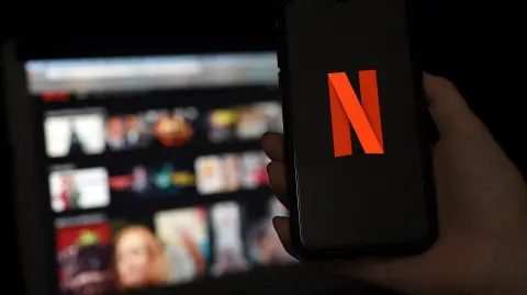 Netflix logo móvil y plataforma en pantalla.