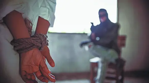 Back view of hostage woman with tie rope in hands,The thief pointed his gun towards him.