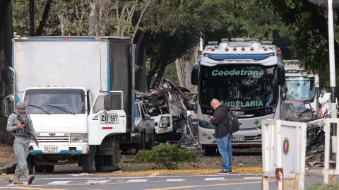 Miembros de las fuerzas de seguridad colombianas inspeccionan el área de la explosión de una bomba en Cali, Colombia.
