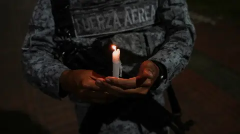 Un miembro de las Fuerzas Armadas de Colombia participa en una vigilia con velas en honor a las víctimas de un ataque con bomba.