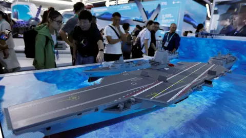 Visitantes observan un modelo del portaaviones Fujian Tipo 003 exhibido en la Exposición Internacional de Aviación y Aeroespacial de China.