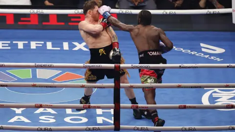 LAS VEGAS, NEVADA - SEPTEMBER 13: Terence Crawford (R) lands a left punch at Canelo Alvarez (L) in their undisputed super middleweight title fight during Netflix's Canelo v Crawford Fight Night at Allegiant Stadium on September 13, 2025 in Las Vegas, Nevada.   Harry How/Getty Images for Netflix/AFP (Photo by Harry How / GETTY IMAGES NORTH AMERICA / Getty Images via AFP)