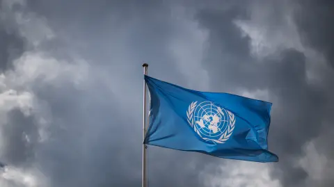 A flag of the United Nations (UN) waves under a cloudy sky at the United Nations Offices in Geneva on September 15, 2025, the day of a press conference on the human rights situation in Gaza.  (Photo by Fabrice COFFRINI / AFP)