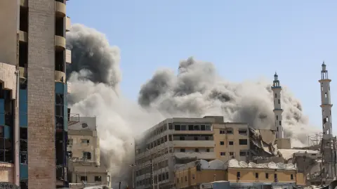 Smoke billows as Israeli airstrikes destroy the al-Ghafari tower in Gaza City on September 15, 2025. Israel's military had said on September 9 that it will act with "great force" in Gaza City and ordered residents to leave as it stepped up a deadly assault on the Palestinian territory's largest urban centre. (Photo by Omar AL-QATTAA / AFP)